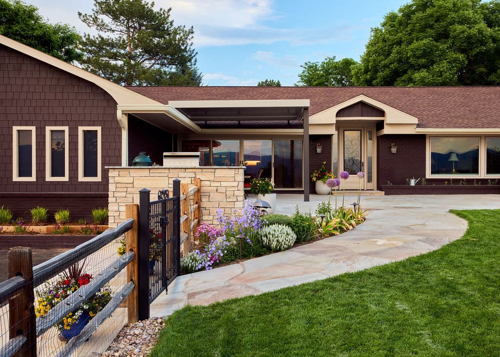 Modern ranch-style home with stone accents, landscaped garden, and outdoor seating area.